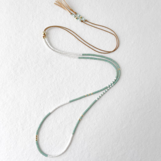 dainty beaded necklace on adjustable beige silk cord with tiny glass beads in aqua and white
