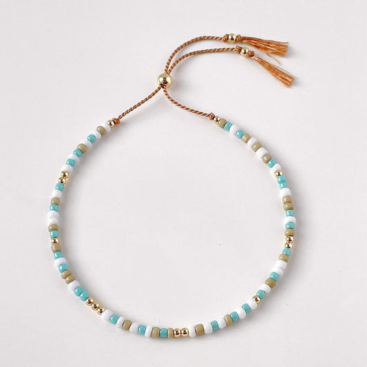 Beaded necklace with tassels on a light gray background