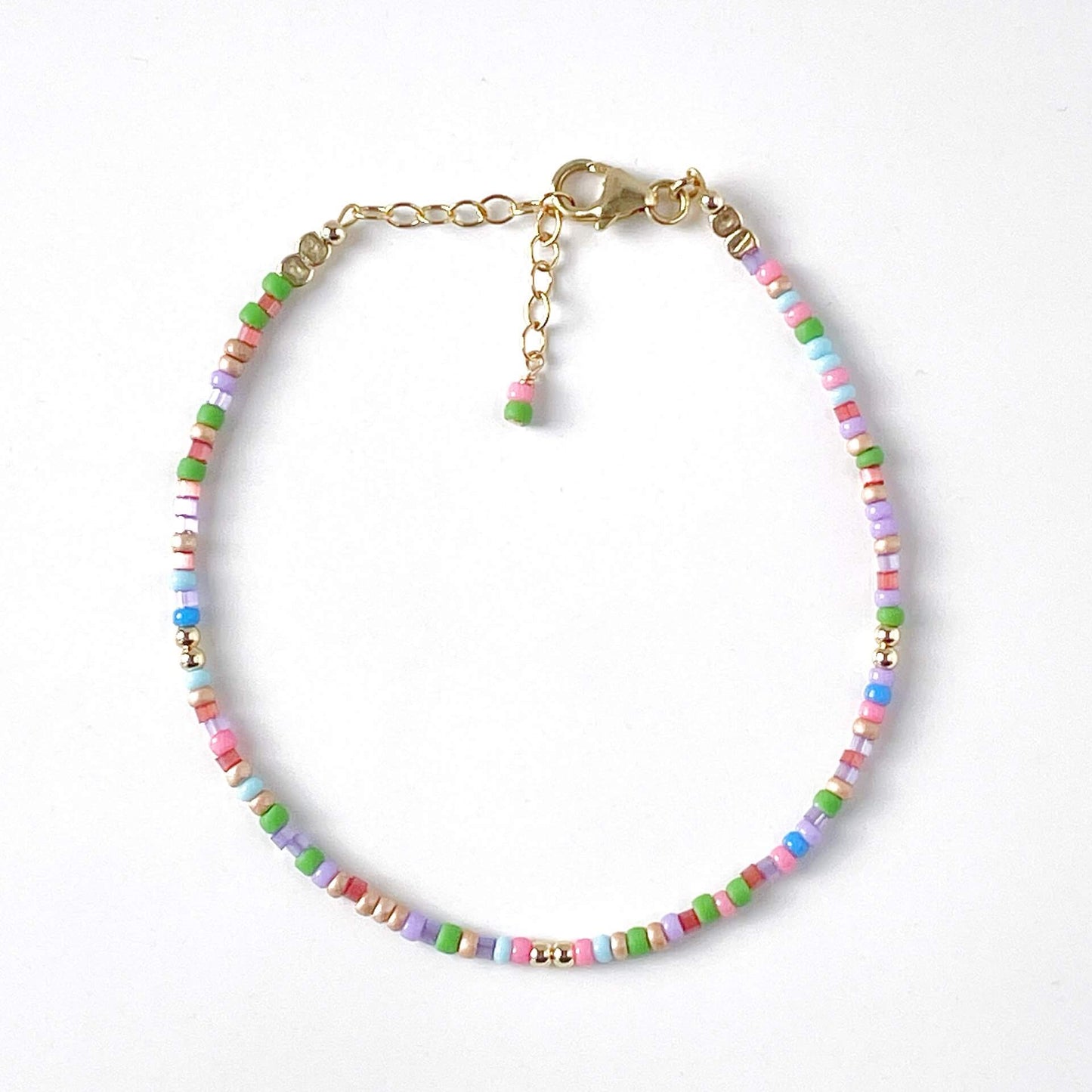 Multicolored beaded bracelet with a gold clasp on a white background