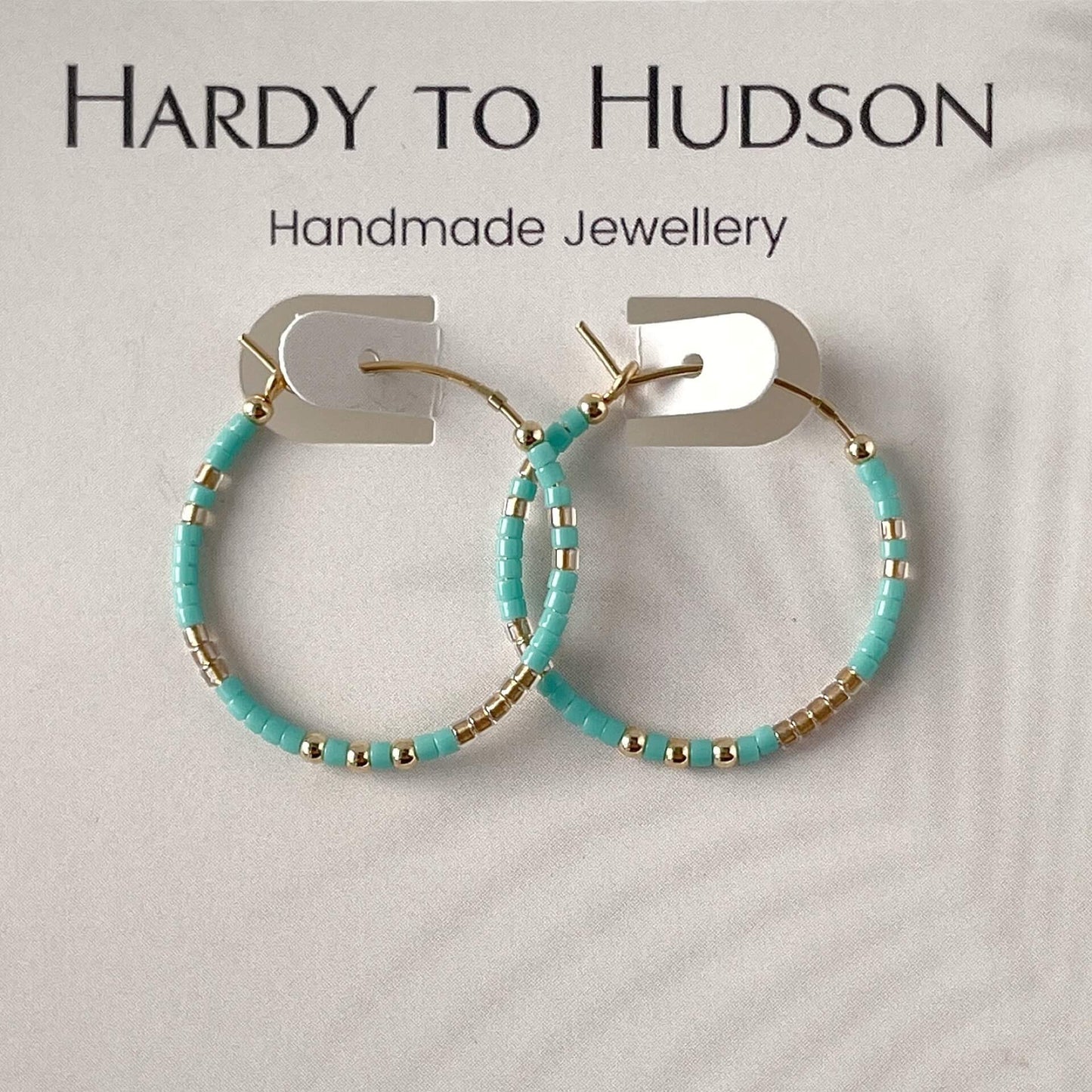 gold hoop beaded earrings with turquoise and gold glass beads and 2mm gold filled beads displayed against a hardy to Hudson earring display card