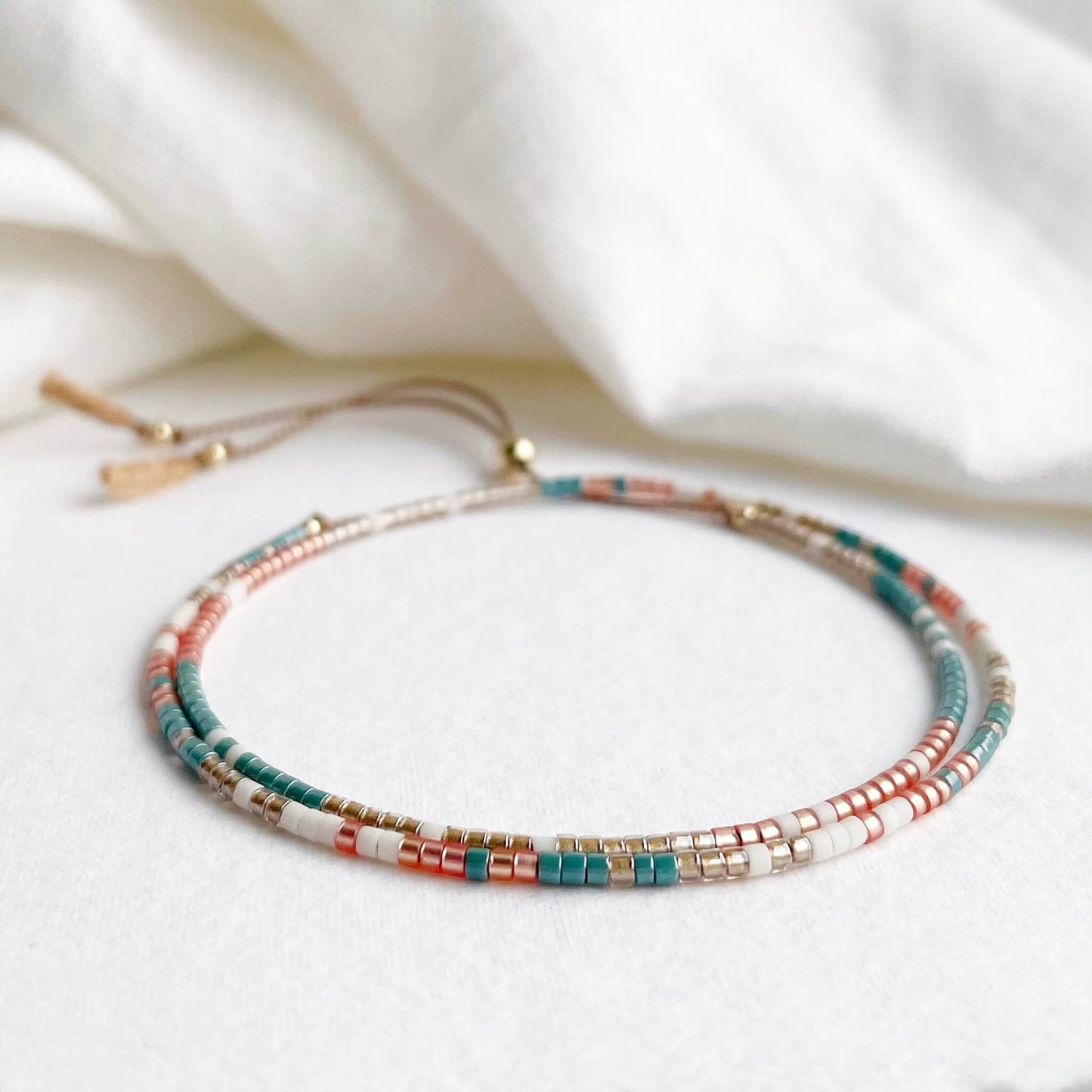 Colorful beaded double wrap bracelet in teal, golden orange and pale gold with gold fill