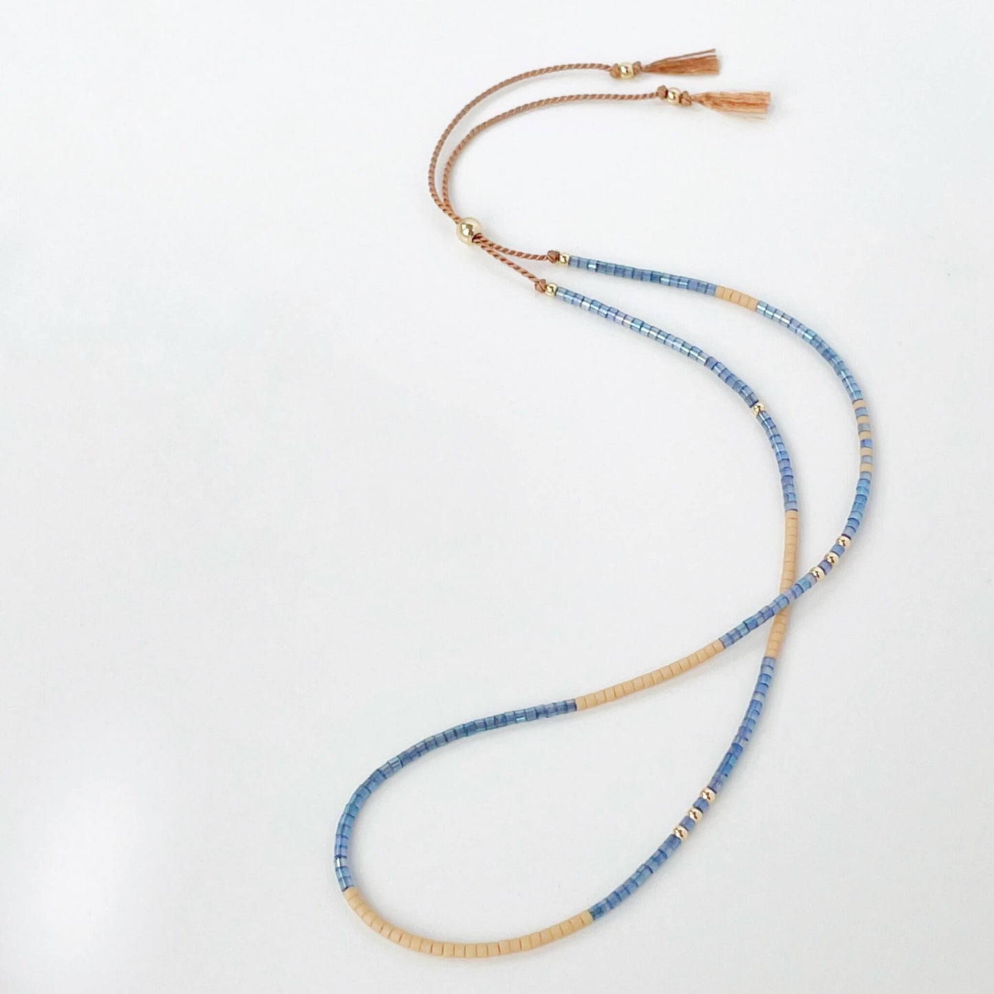 Beaded bracelet with blue and gold beads on a white background