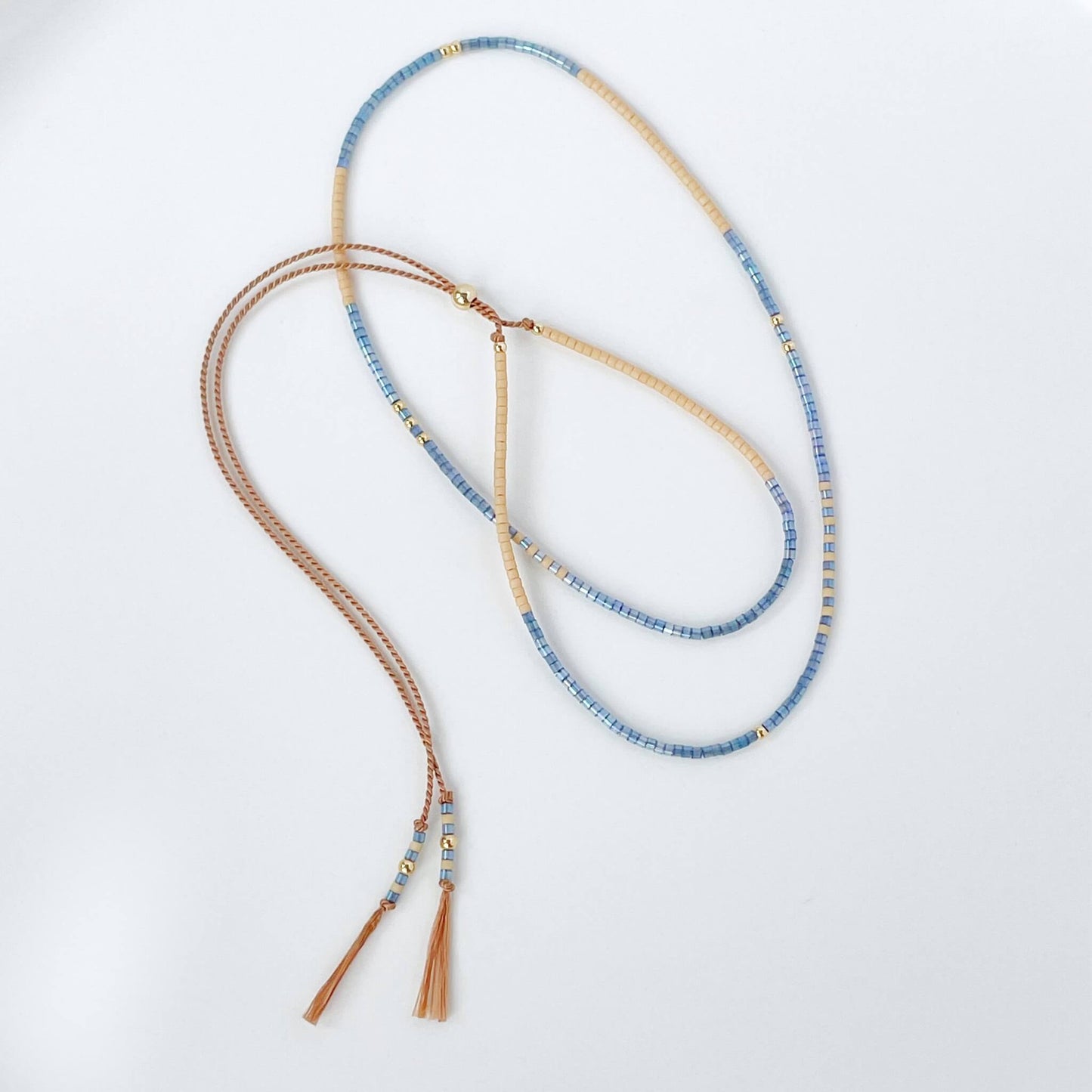 dainty beaded beige silk cord necklace with denim blue and sandy beige Miyuki beads with gold fill accents and tassel ends