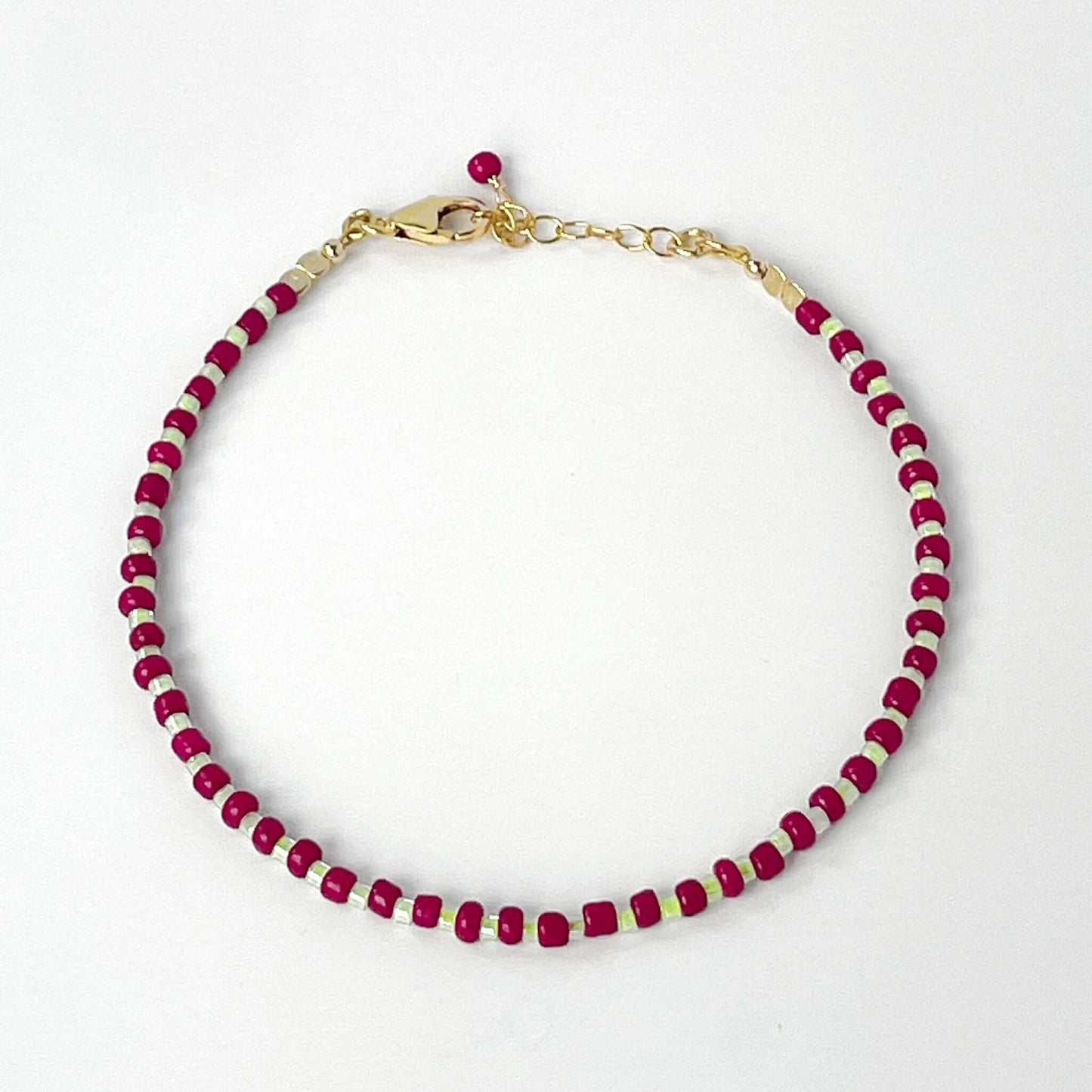 Bracelet with burgundy and gold beads on a white background