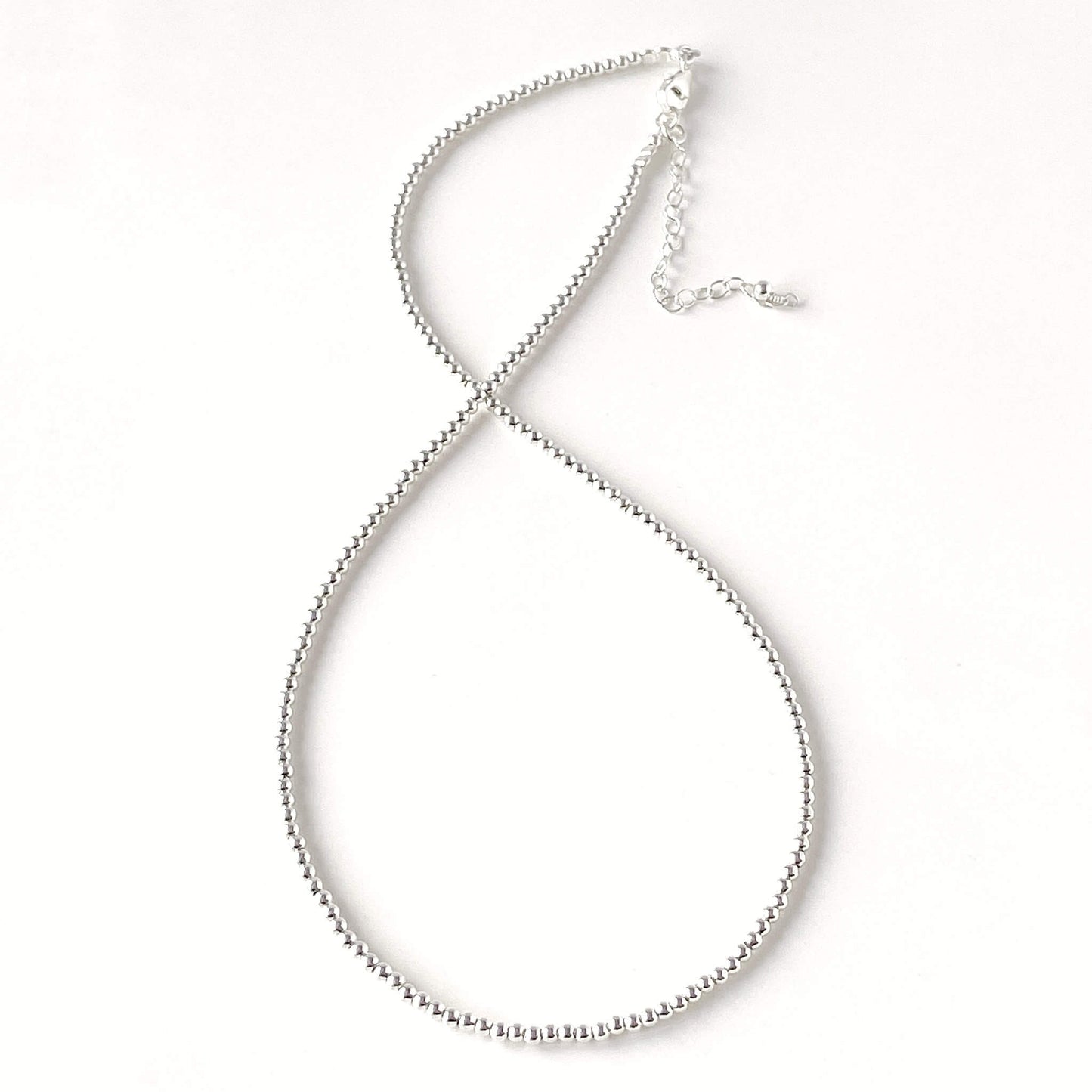 Silver beaded necklace on a white background