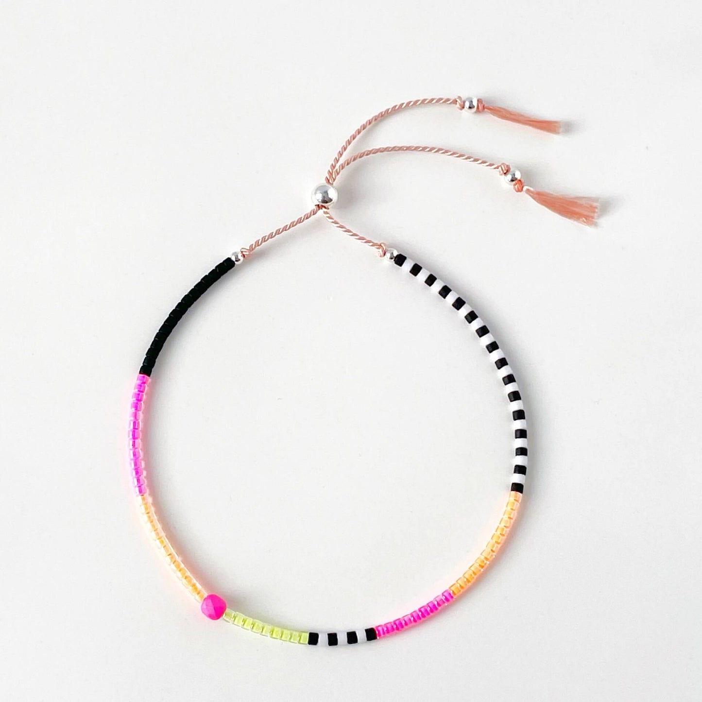 Sterling silver accent beads and vibrant neon Japanese glass beads on adjustable pink silk cord bracelet