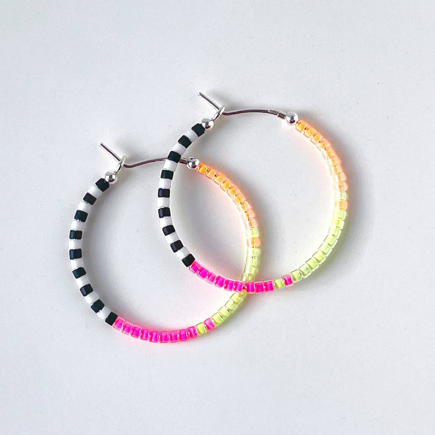 Sterling silver hoop earrings with neon pink, yellow, orange, black and white glass beads