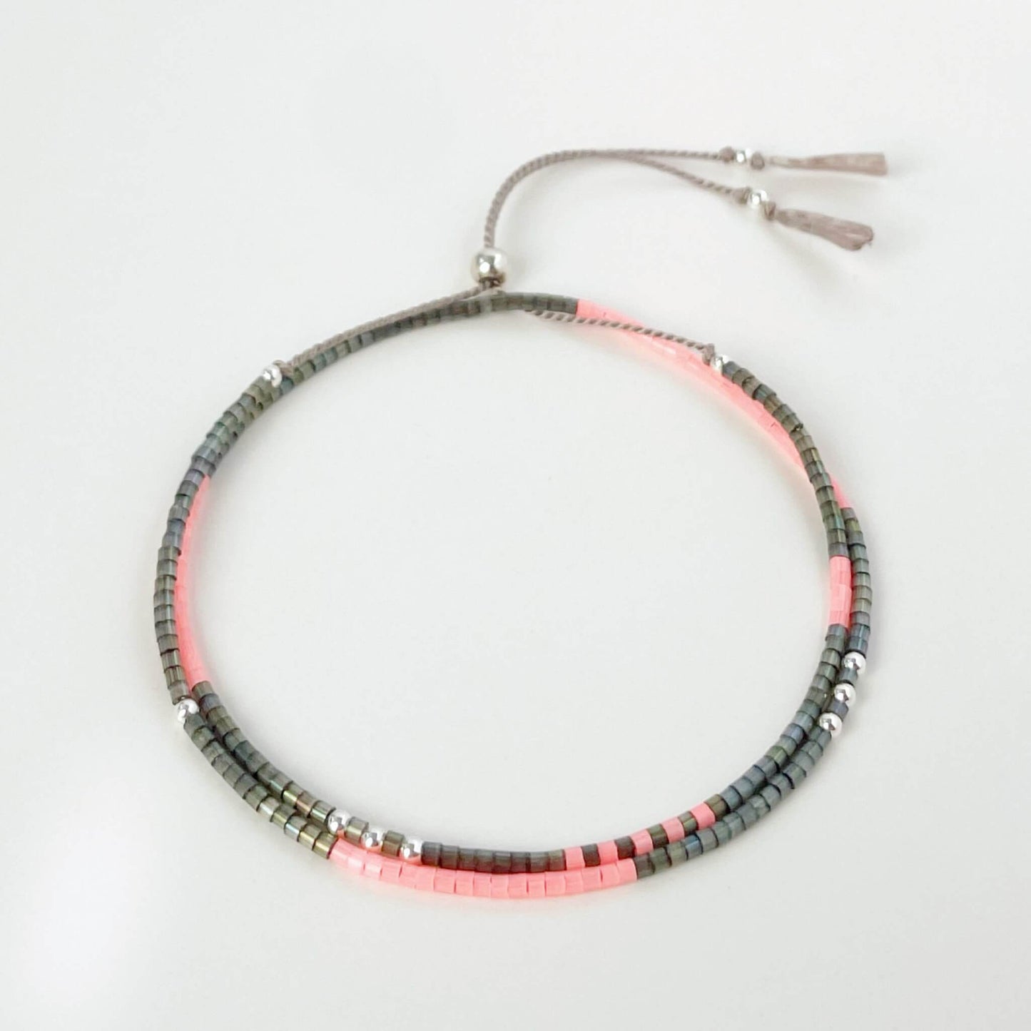 Necklace with pink and gray beads on a light light grey background