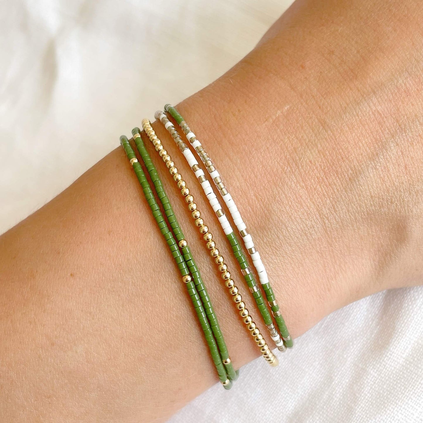 Trio of bracelest shown worn on a wrist, 2 double wraps and 1 gold beaded single