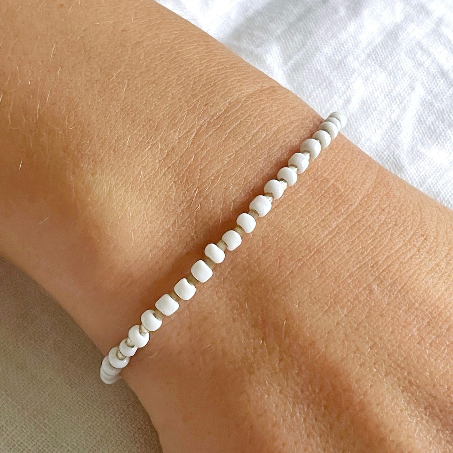 white and beige beaded bracelet worn on the wrist
