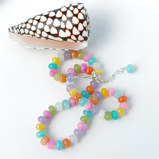 Colorful beaded necklace with a shell on a white background