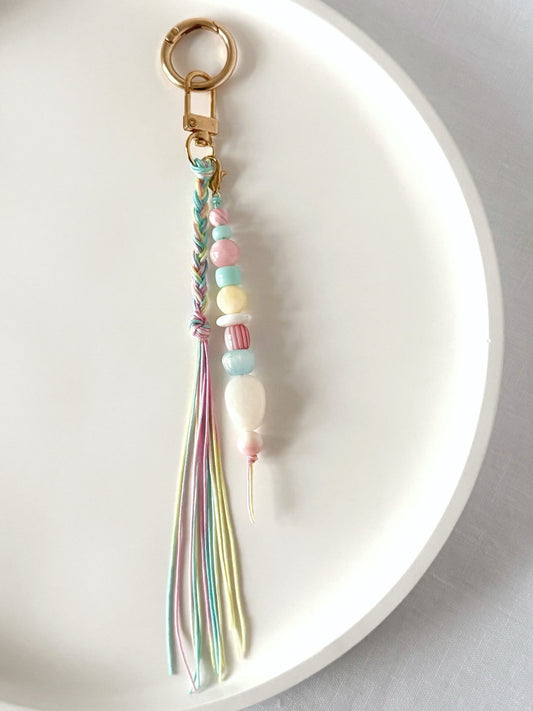 pastel chunky bead bag charm in pink, blue, lemon and white with a braided tassel in nylon cords in pink, blue and yellow