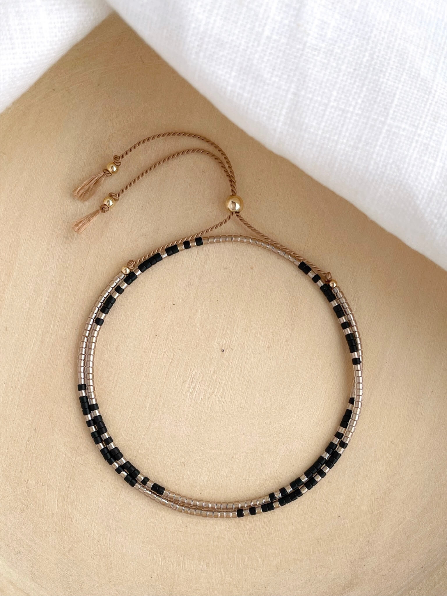 Minimal double wrap bracelet with pale gold and black beads and gold fill accents