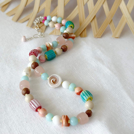 Colorful beaded necklace on a white fabric background