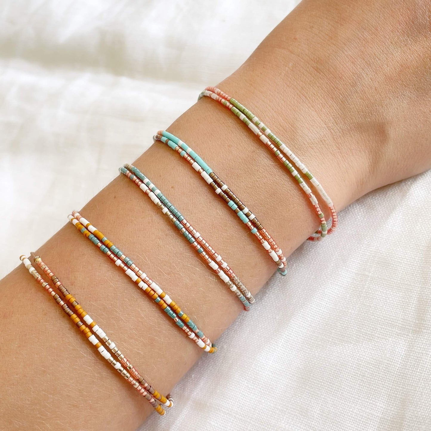 five double wrap beaded double wrap bracelets shown worn on a wrist 