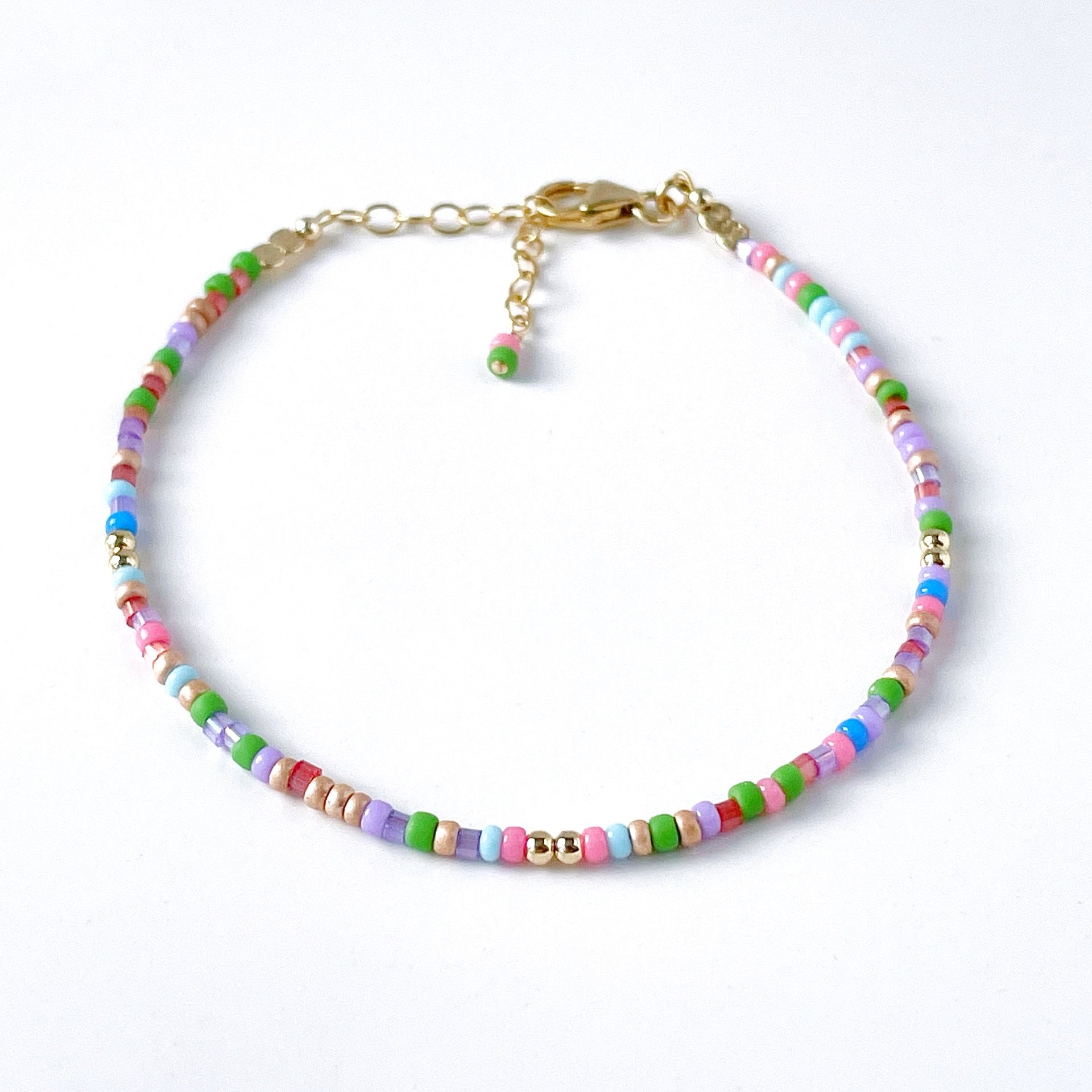 Colorful beaded bracelet with pink, blue, green, red, purple and lilac beads with gold fill accents