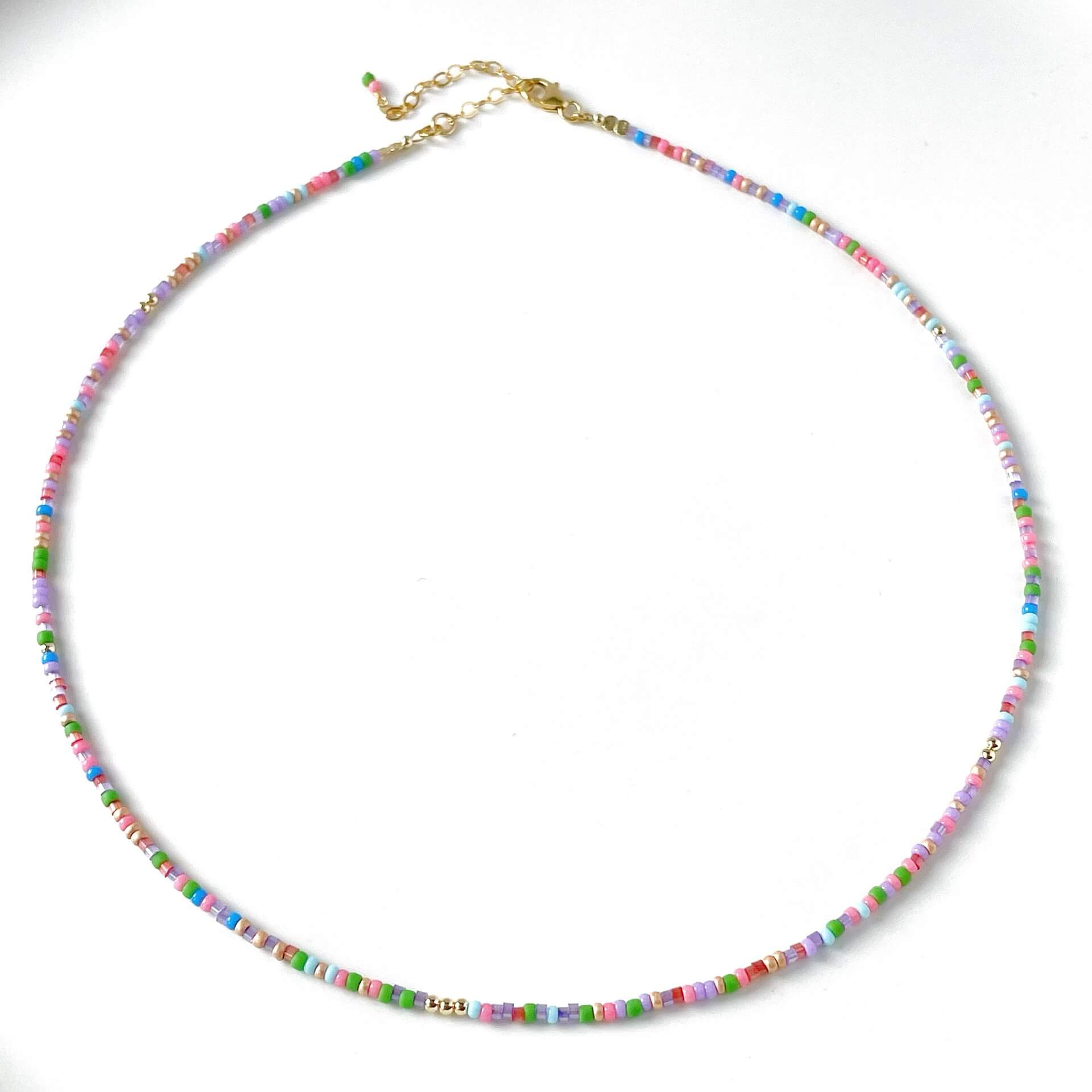 Colourful beaded necklace with a gold clasp and extension chain on a white background
