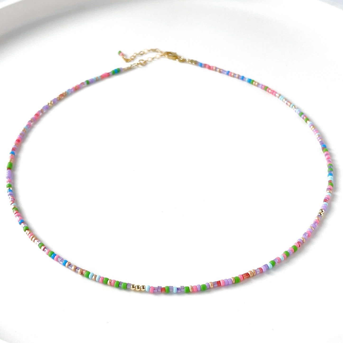 dainty beaded necklace with pink, blue, red, green and lilac beads with gold fill clasp and extender chain