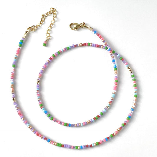 Colorful beaded necklace with a gold chain on a white background