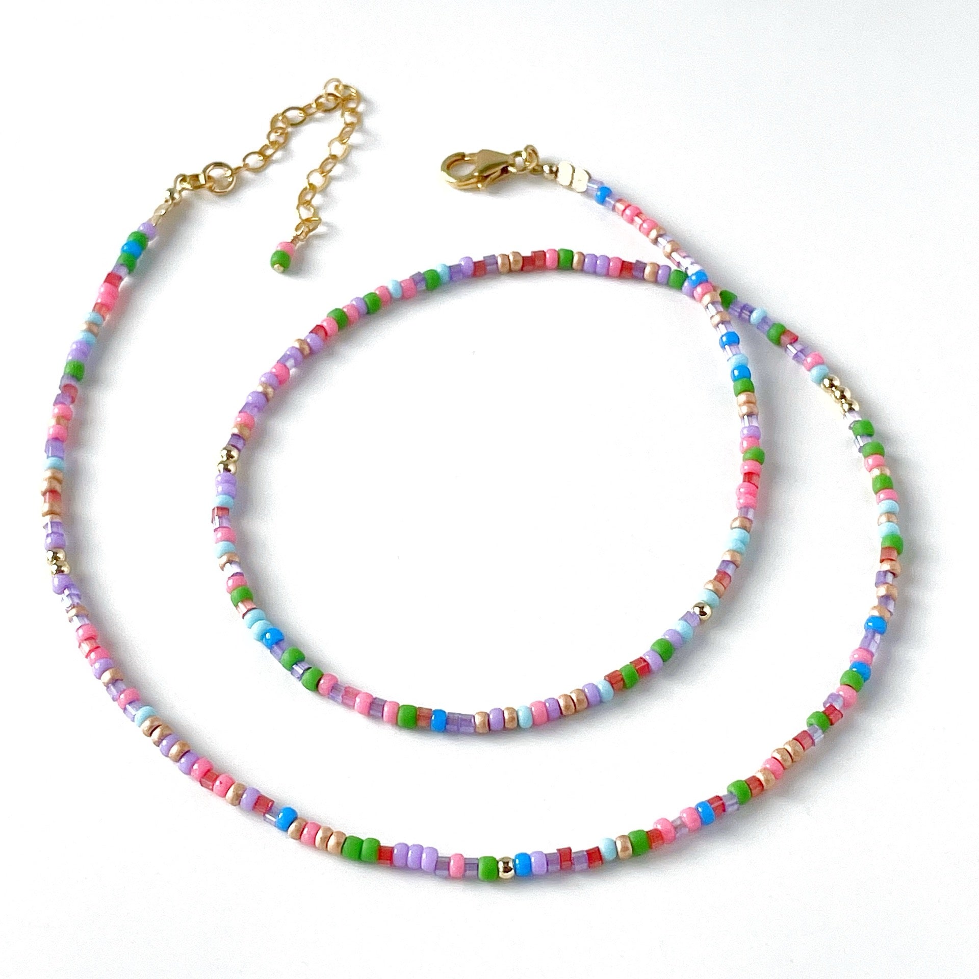 Colourful beaded necklace with pink, blue, red, green and lilac beads with gold fill accents