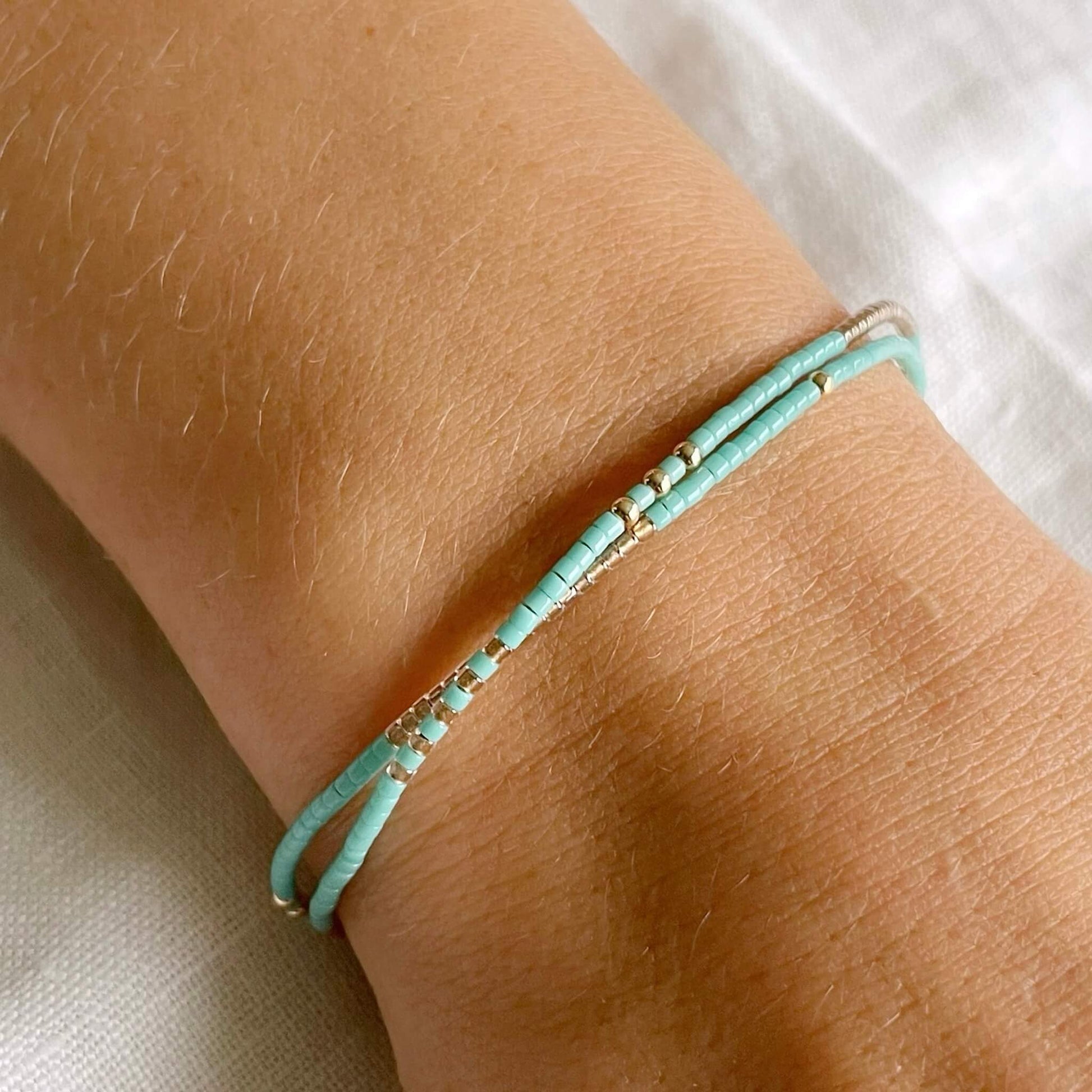 Ocean inspired double wrap bracelet with turquoise beads shown worn on wrist