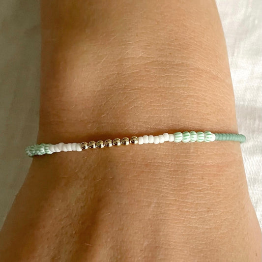 Green, white and sandstone bead bracelet with gold-fill clasp worn on wrist