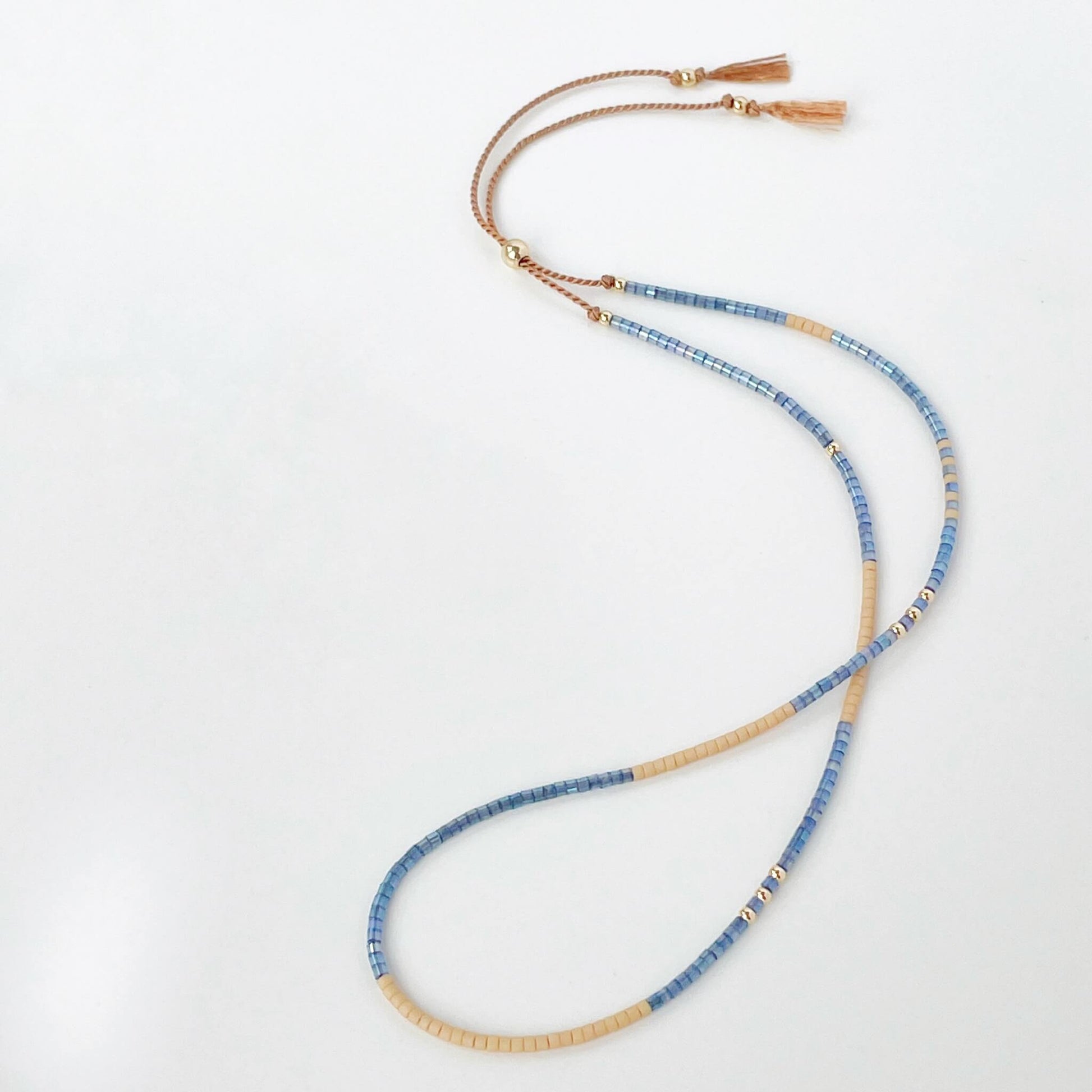 Beaded bracelet with blue and gold beads on a white background