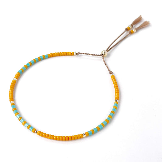 Beaded bracelet with orange and turquoise beads on a white background