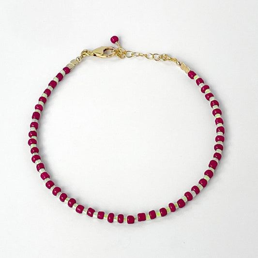 Bracelet with burgundy and gold beads on a white background
