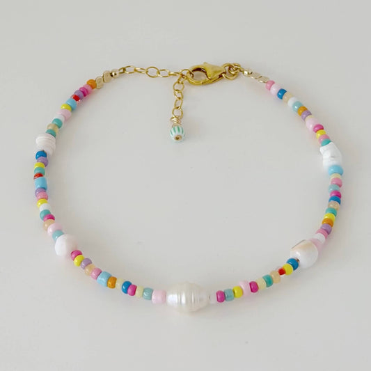 Colourful glass bead and shell bracelet with gold fill clasp and extender chain on a white flat lay surface