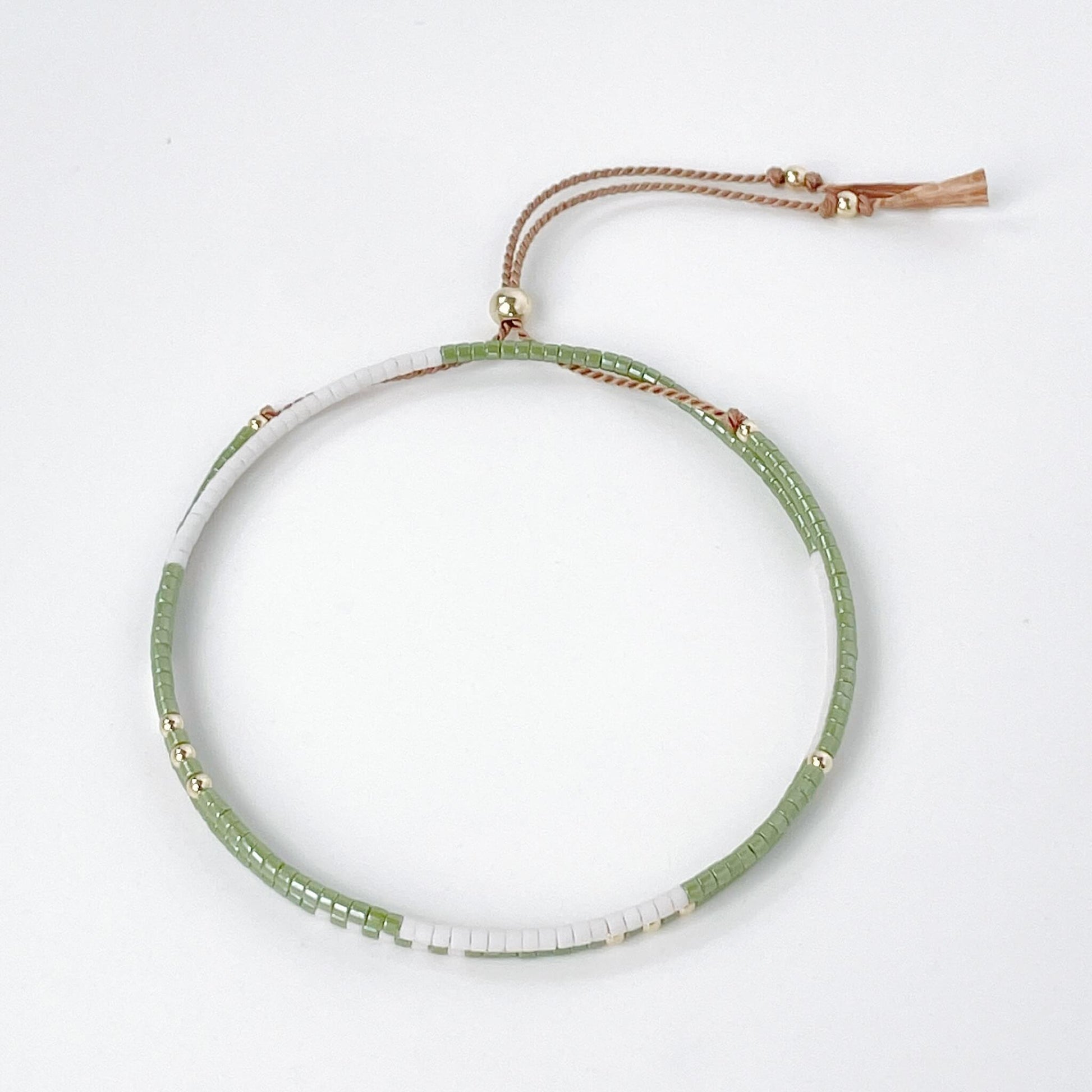 double wrap bracelet moss green and soft white Miyuki beads on a beige silk cord with tassel ends and a gold fill slider bead
