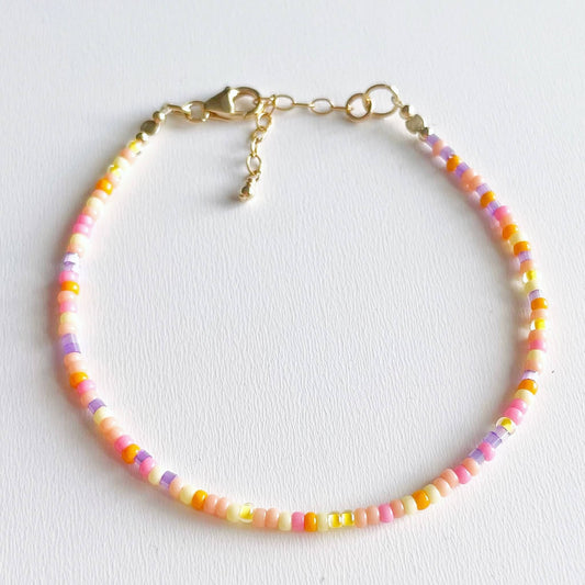 dainty beaded bracelet with pink, yellow, orange and lilac glass beads and gold fill accents