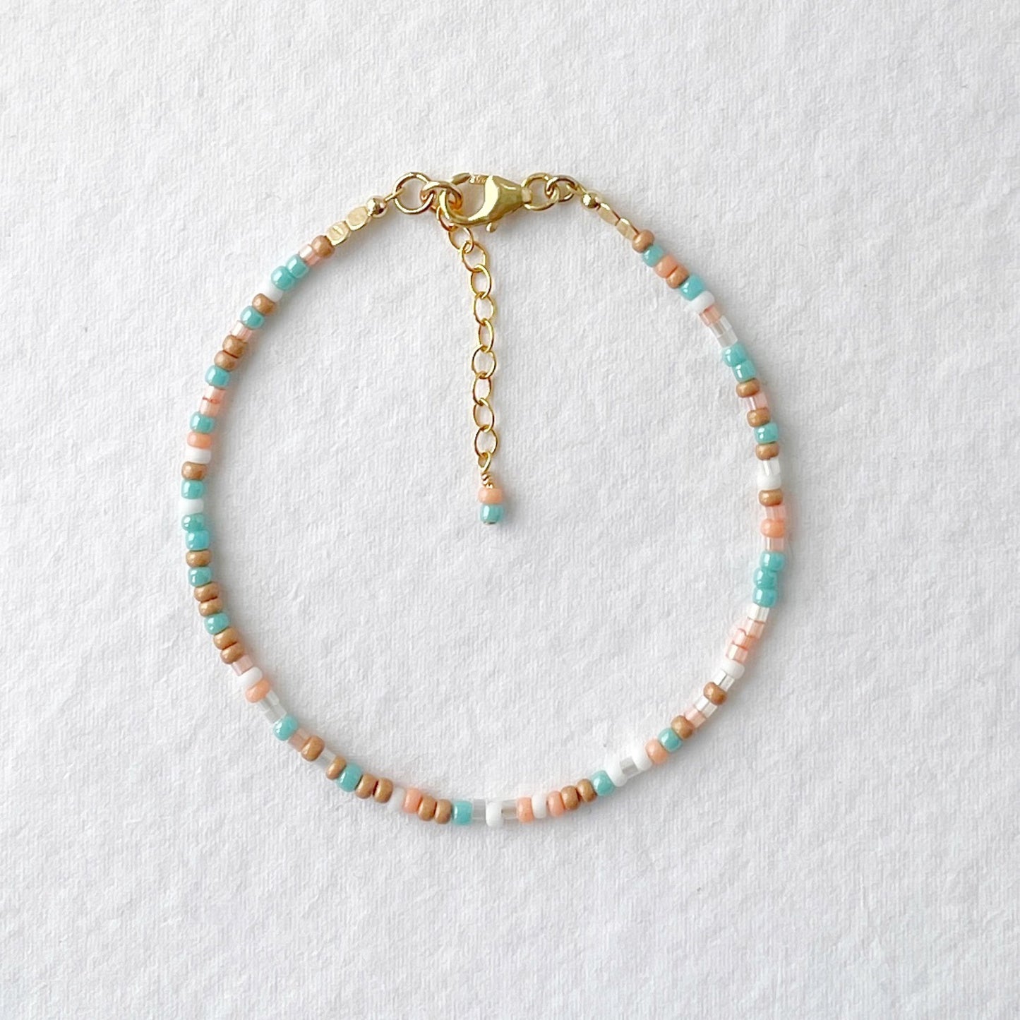Beaded bracelet in aqua, peach, white, and golden beige with gold fill clasp—Sunrise Surf design by Hardy to Hudson