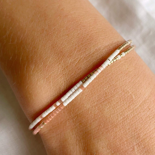 Minimal double wrap bracelet with peach and gold beads shown worn on wrist