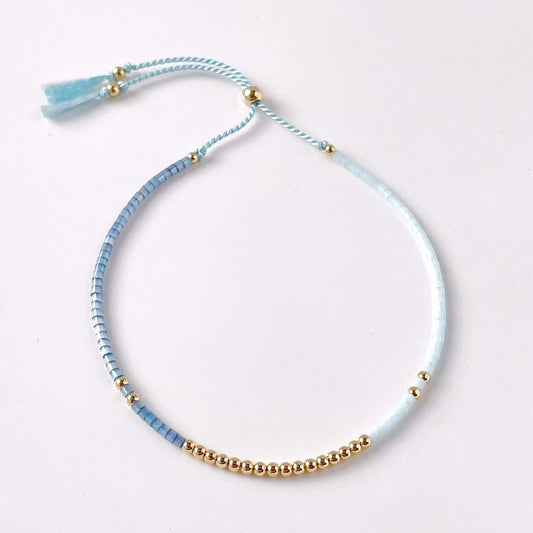 Dainty faceted blue glass bead bracelet with pale and mid blue beads and 14k gold filled accent beads in the centre 