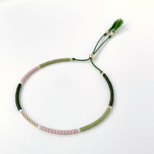 Dainty beaded bracelet with dusty pink, moss green, white, and dark olive Miyuki beads on olive silk cord with gold fill accents