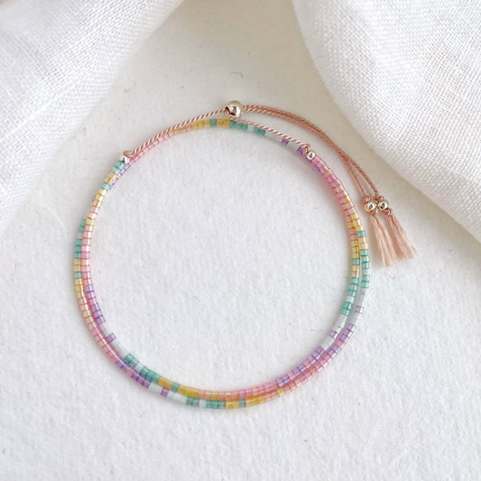 sparkling beaded double wrap bracelet in pink, peach, yellow, green, blue and lilac with sterling silver accents on a pink cord