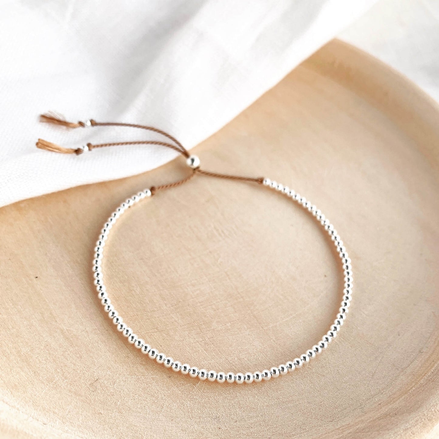 Minimal sterling silver beaded bracelet on adjustable silk cord