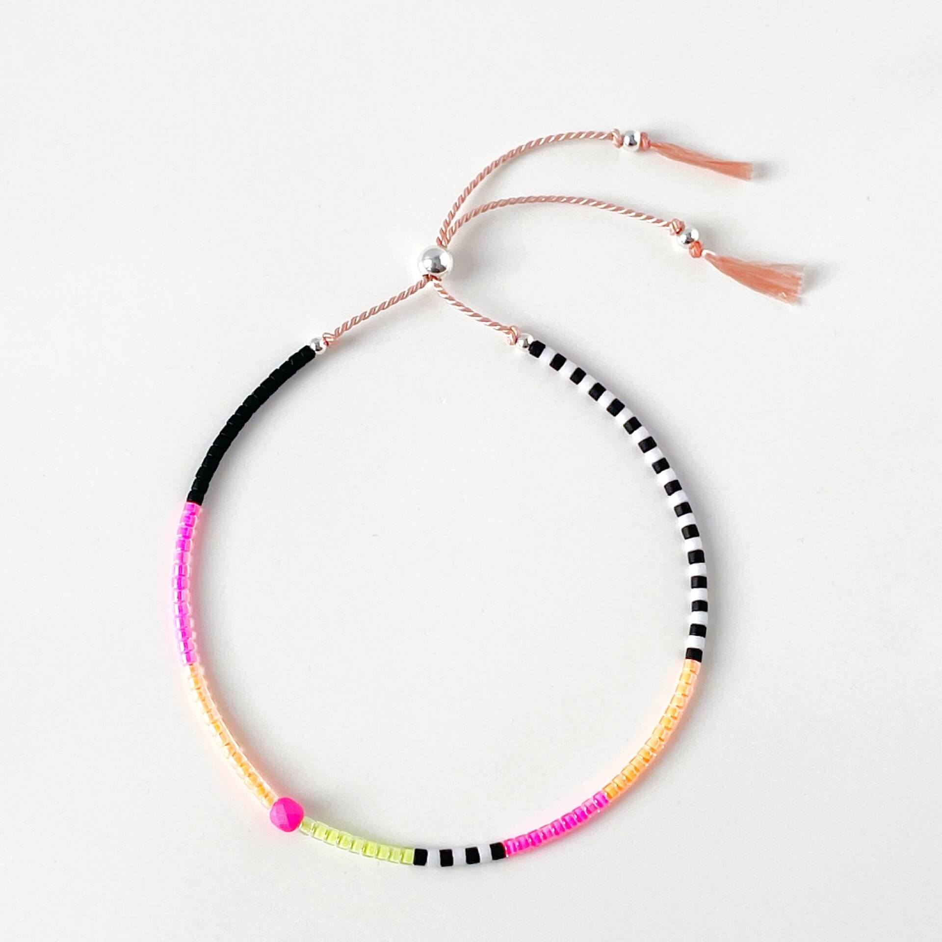 Sterling silver accent beads and vibrant neon Japanese glass beads on adjustable pink silk cord bracelet