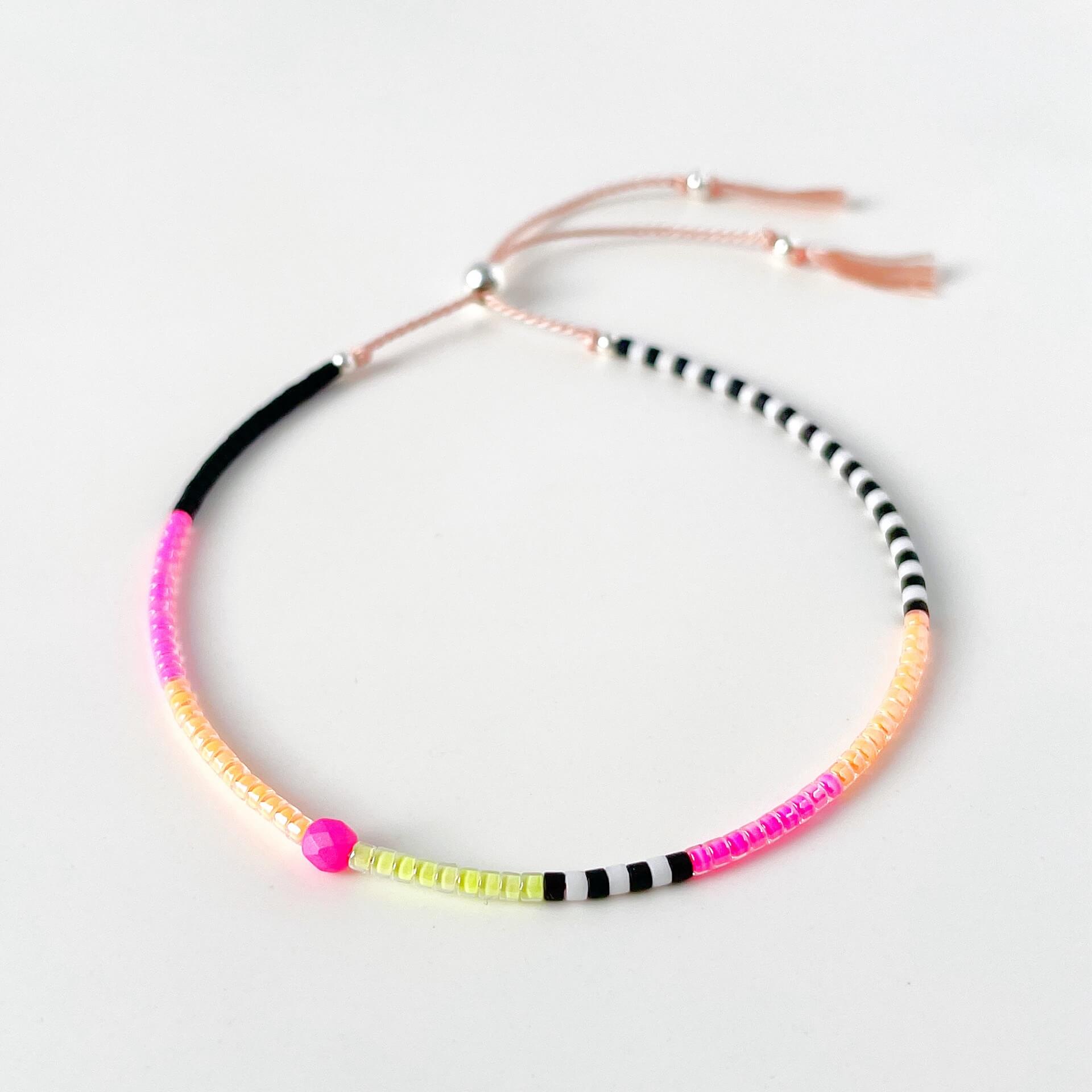 Neon pink, yellow and orange glass bead bracelet with black and white beads on soft pink silk cord