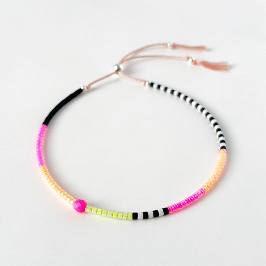 Neon pink, yellow and orange glass bead bracelet with black and white beads on soft pink silk cord
