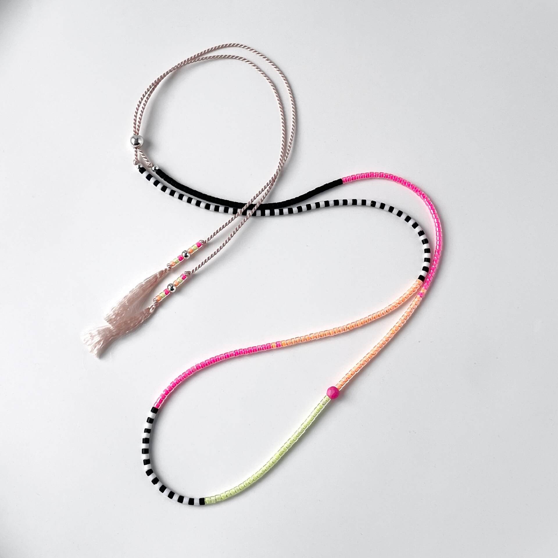 Neon pink, yellow and orange glass bead necklace with black and white beads on soft pink silk cord