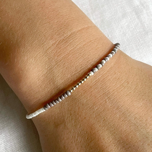 Beige & white glass beaded bracelet with gold fill accents, inspired by driftwood worn on the wrist