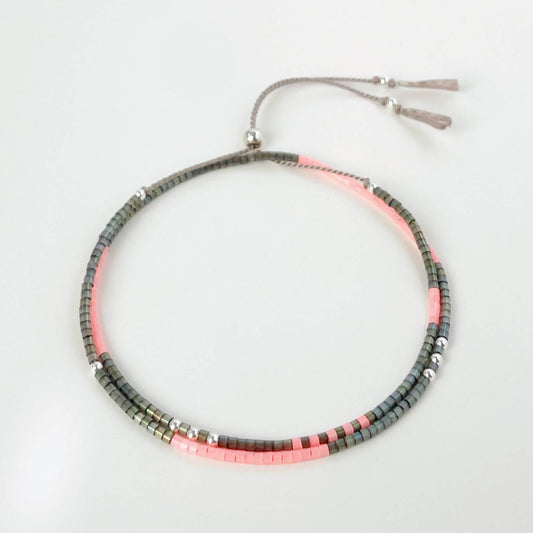 Necklace with pink and gray beads on a light light grey background