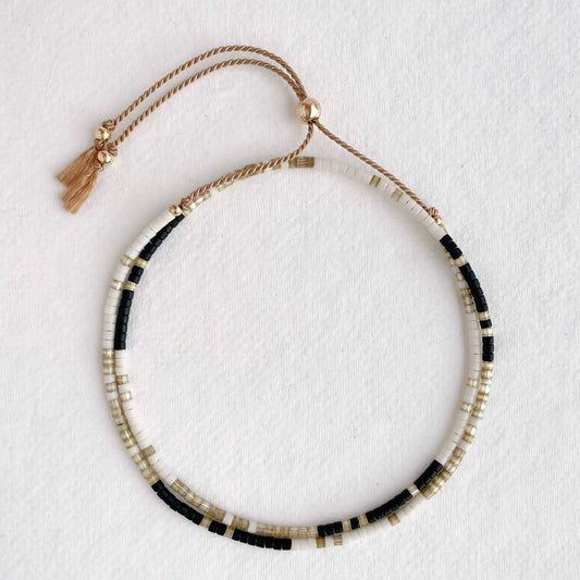 Double wrap silk bracelet with taupe, white, and black beads and gold accents