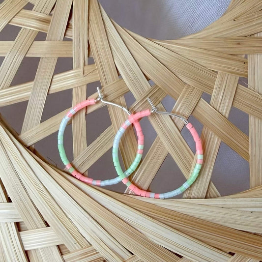 Mint green, flamingo pink and pale blue glass beaded sterling silver hoop earrings on a rattan background